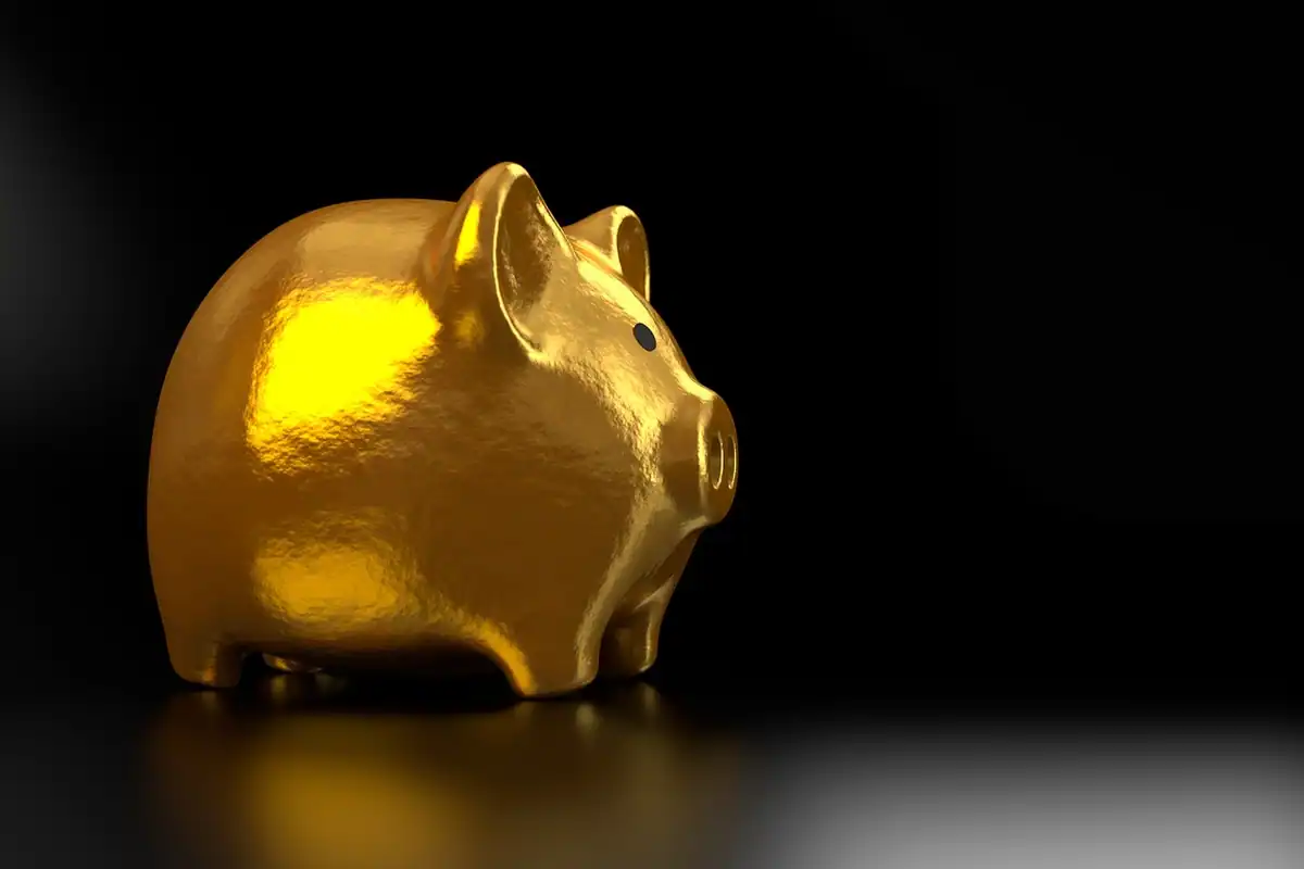 Pușculiță aurie în formă de porc pe fundal negru, simbol al economiilor pe termen lung