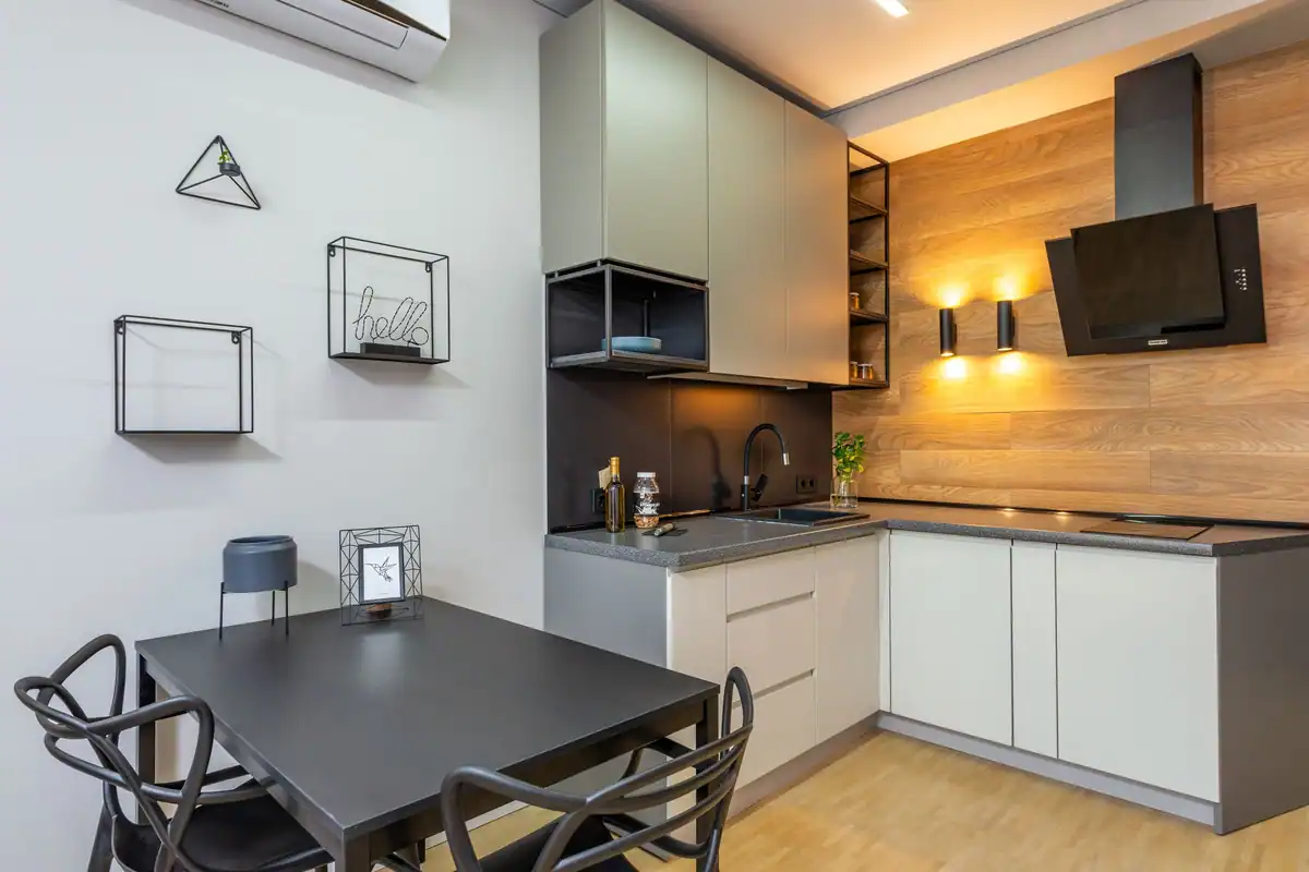 Bucătărie mică și modernă cu masă neagră și scaune, într-un apartament simplu